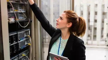Técnica em data center ajustando servidores.