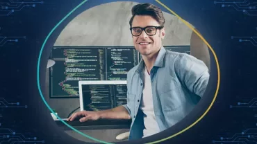 Homem usando óculos trabalhando em um computador com código na tela.