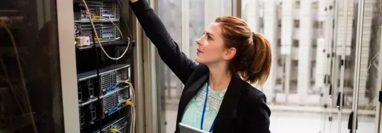Técnica em data center ajustando servidores.